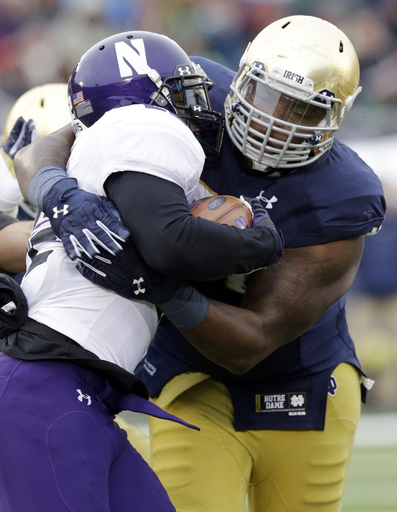 AP photo 
 In this Nov. 15, 2014, file photo, Notre Dame defensive lineman Jarron Jones, right, tackles Northwestern running back Treyvon Green during the first half of a game in South Bend, Ind. Jones, a returning starter who made 40 tackles last season, tore the medial collateral ligament in his right knee.
