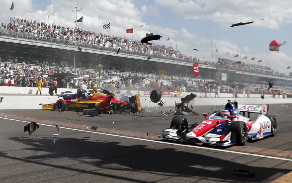In this May 2014 file photo, Sebastian Saavedra, left, is hit by Mikhail Aleshin as Takuma Sato, right, drives past on the start of the inaugural Grand Prix of Indianapolis at the Indianapolis Motor Speedway. The IndyCar Series has bounced from one problem to another all season as it scrambles for viewers and new fans. It heads into the season finale this weekend after suffering the worst possible blow: The death of a driver, with Justin Wilson dead at 37 from injuries suffered in a crash.