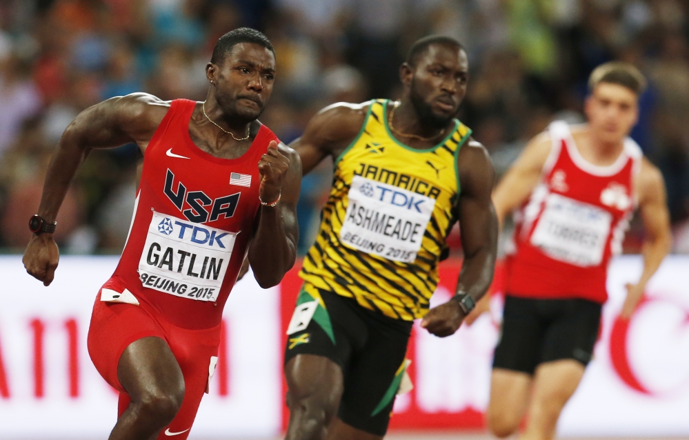 Justin Gatlin, left, races in a round one heat alongside Nickel Ashmeade of the men’s 200m at the World Athletics Championships on Tuesday at the Bird’s Nest stadium in Beijing.