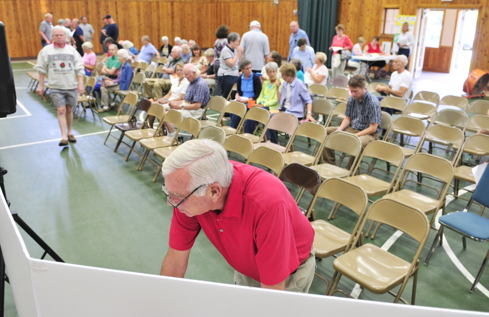 Gordon Pow looks over Town Office construction plans on display Saturday before a special town meeting at the Belgrade Community Center for All Seasons.