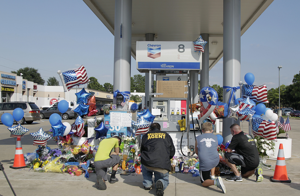 Mourners gather at a gas station in Houston on Saturday to pay their respects at a makeshift memorial for Harris County Sheriff’s Deputy Darren Goforth who was shot and killed while filling his patrol car.