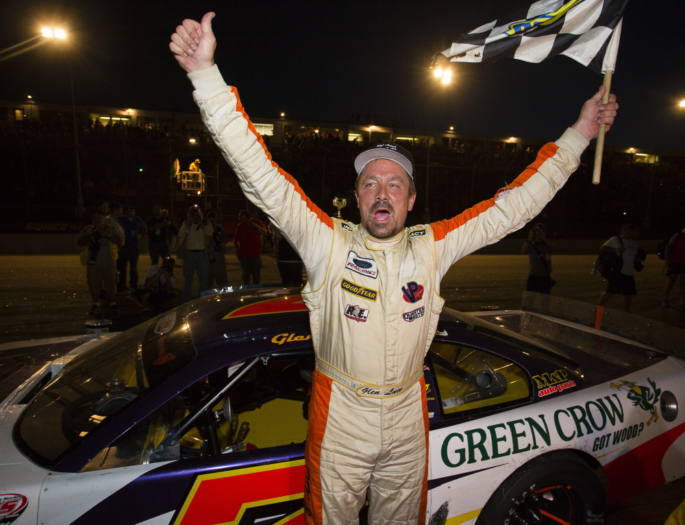 Glen Luce, of Turner, raises the checkered flag after winning the Oxford 250 at Oxford Plains Speedway on Sunday.
