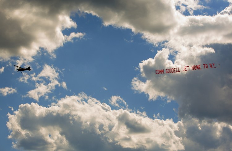 A plane tows a banner with the message “Comm. Goodell Jet Home to N.Y.” over Biddeford Municipal Airport on Sunday.