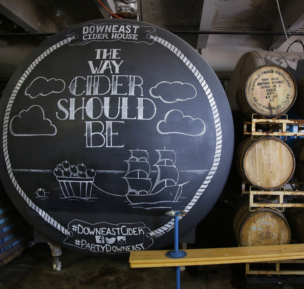 A storage tank and wooden whiskey barrels hold hard cider at Downeast Cider House in Boston. The company expects to produce 17,000 barrels of cider this year.