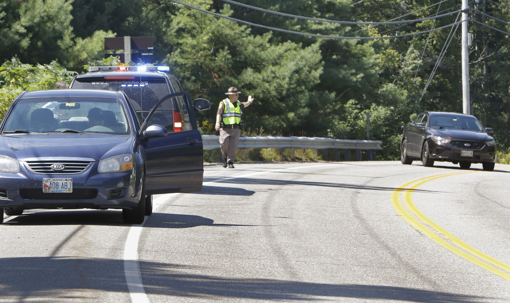 A Cumberland County Sheriff's Deputy directs traffic on Harpswell Islands Road in Harpswell on Wednesday near the scene where Isabella Slocum, 16, struck and killed Rita Douglas, 75, while she was walking her dog. 