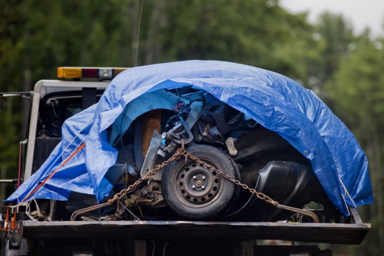 The mangled remains of the front of a vehicle that struck a telephone pole on Route 11 on August 11, are towed away from the scene.  Gabe Souza/Staff Photographer
