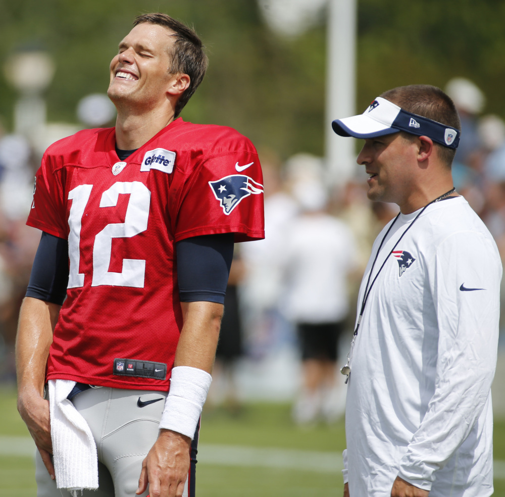 Patriots quarterback Tom Brady shares a laugh with offensive coordinator Josh McDaniels during a joint practice Thursday with the New Orleans Saints.