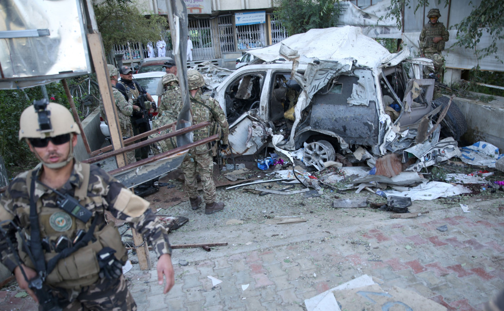 Afghan security forces and British soldiers inspect the site of a suicide attack in the heart of Kabul, Afghanistan, on Saturday. The car bomber attacked a NATO convoy traveling through a crowded neighborhood in Afghanistan’s capital Saturday, killing at least 10 people, including Corey Dodge of Garland, and two other NATO contractors.