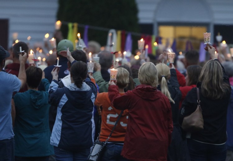 Mourners hold candles Sunday evening during a vigil for Wendy Boudreau at the Cornerstone United Methodist Church in Saco. Boudreau was killed Wednesday while shopping at a Shaw’s supermarket in Saco. 