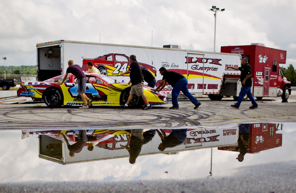Numerous helping hands push Gunnar Rowe’s stock car back to its trailer Wednesday. The 15-year-old Rowe will attempt to qualify for the Oxford 250 on Sunday.