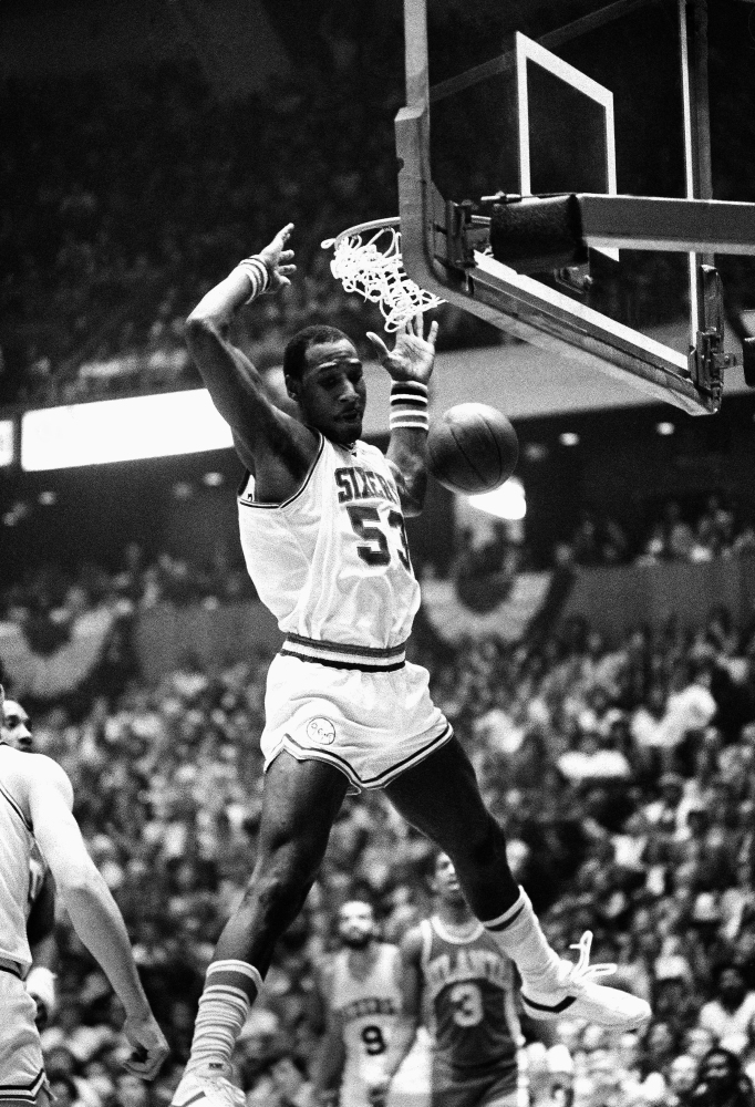 Darryl Dawkins dunks against the Atlanta Hawks while playing for the Philadelphia 76ers in an NBA playoff game in 1980. Dawkins, whose backboard-shattering dunks helped pave the way for breakaway rims, died Thursday at the age of 58.