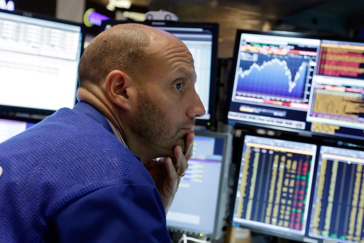 Specialist Meric Greenbaum works at his post on the floor of the New York Stock Exchange on Friday, when the markets closed nearly flat after a wild week.