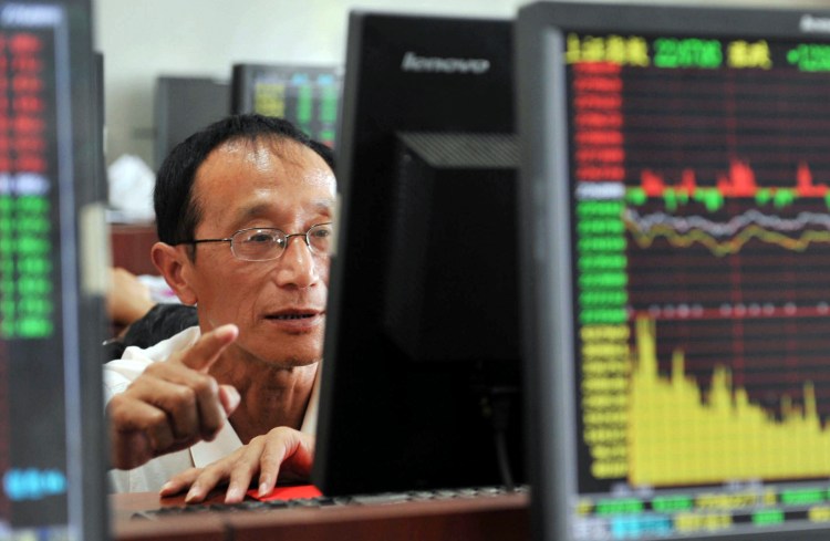 A Chinese stock investor monitors stock prices at a brokerage house in Hangzhou in eastern China's Zhejiang province Tuesday . China's stock market index tumbled for a fourth day, falling 7.6 percent Tuesday to an eight-month low. Chinatopix via AP