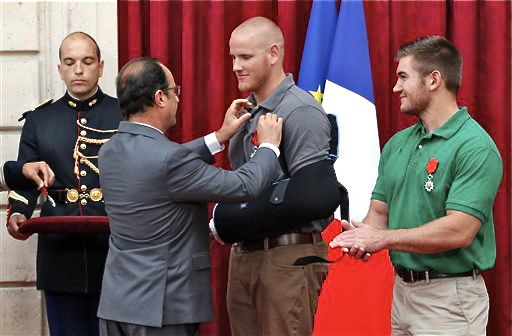 French President Francois Hollande pins the Legion of Honor medal on U.S. Airman Spencer Stone while Alek Skarlatos a U.S. National Guardsman applauds at the Elysee Palace, Monday in Paris. Stone, Skarlatos and their friend Anthony Sadler subdued a gunman as he moved through a train with an assault rifle strapped to his bare chest. A British businessman, Chris Norman, also jumped into the fray, and also received the medal on Monday. The Associated Press