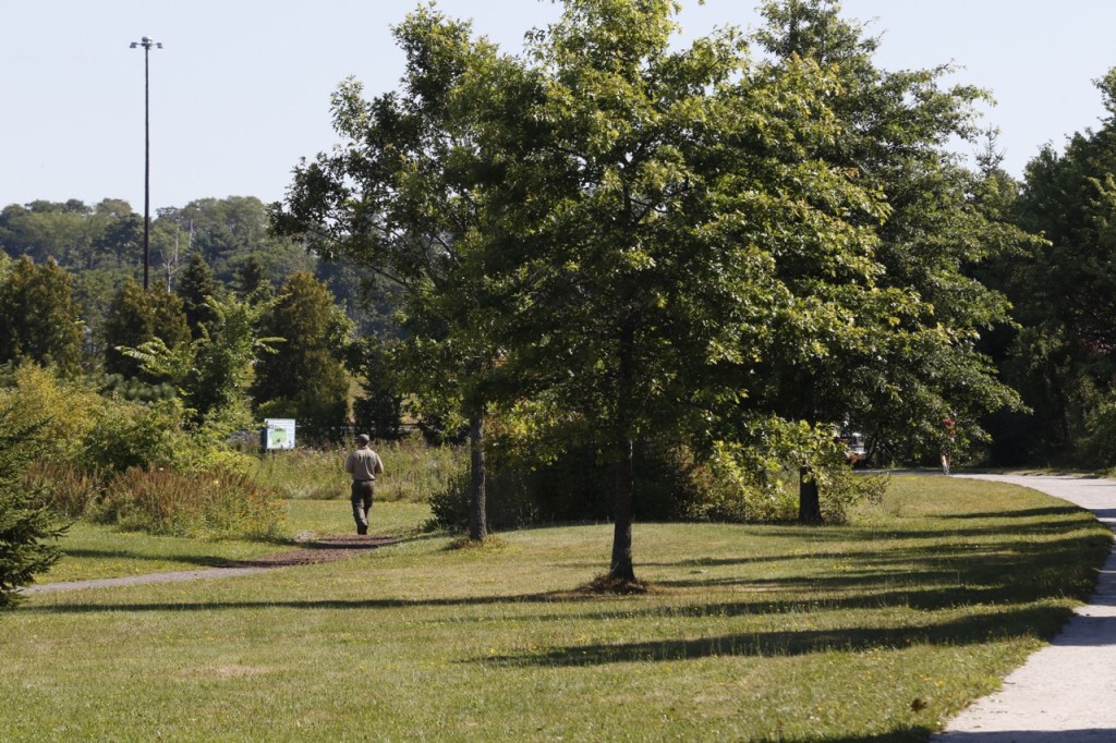 A park ranger walks along the Back Bay Cove trail Thursday, Aug. 13, 2015 in Portland, Maine near the the scene of a reported sexual assault.