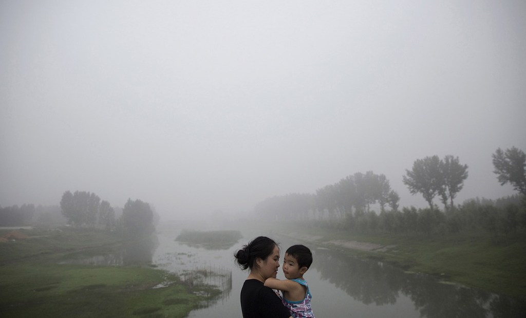 This woman and child are among travelers waiting for the highway from Beijing to China's Hebei Province to be reopened after it was closed for low visibility from heavy air pollution last week.