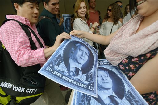 People waiting in line for the taping of Jon Stewart's final episode of "The Daily Show" receive posters of the comedian. Viorel Florescu/The Record of Bergen County via The Associated Press