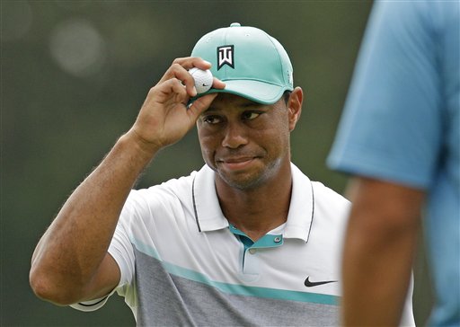 Tiger Woods tips his hat to the crowd after finishing his round on the 18th hole during the first round of the Wyndham Championship golf tournament in Greensboro, N.C., on Thursday. The Associated Press