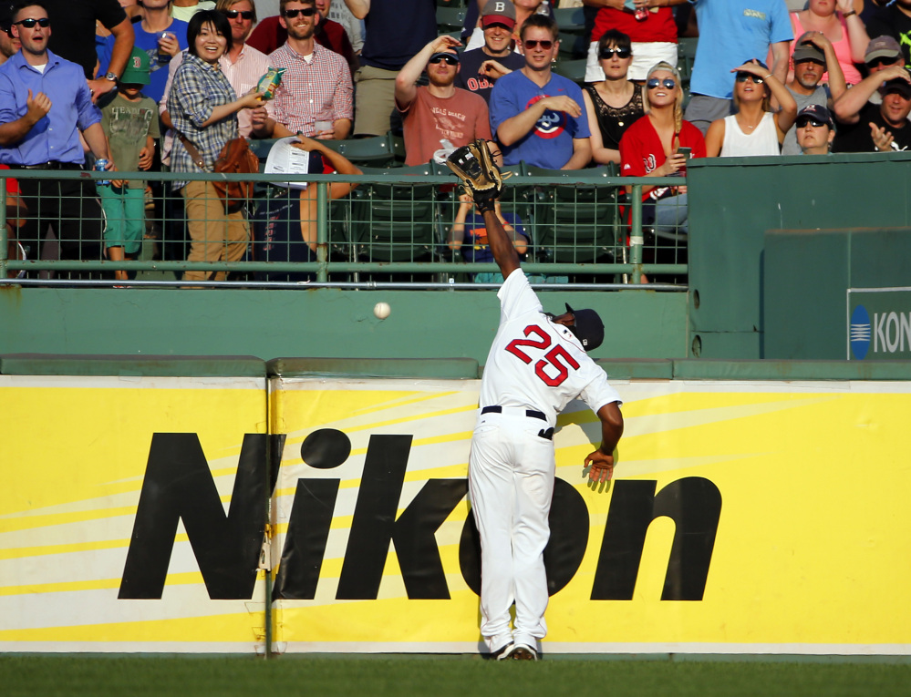 Boston Red Sox right fielder Jackie Bradley Jr. goes up against the wall but can’t get to a home run hit by New York Yankees’ Didi Gregorius during the fifth inning Wednesday at Fenway Park in Boston. New York won 13-8.