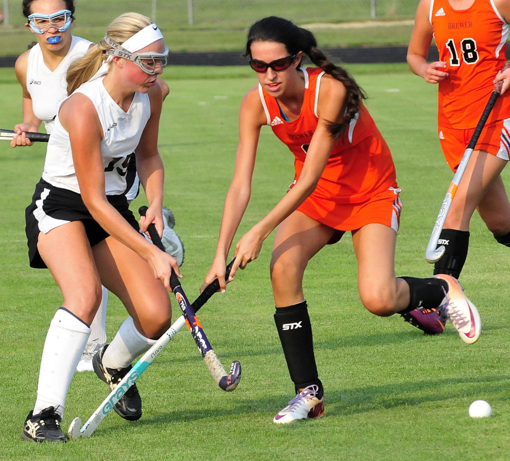 Skowhegan’s Wylie Bedard, left, and Brewer’s Hannah Smith battle for position during the regular season opener Wednesday in Skowhegan. The Indians beat the Witches 11-0.