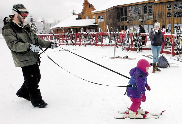 Gabbie Archibald learns to ski with help from her father Ian beside the renovated base lodge at Saddleback ski resort in 2009.