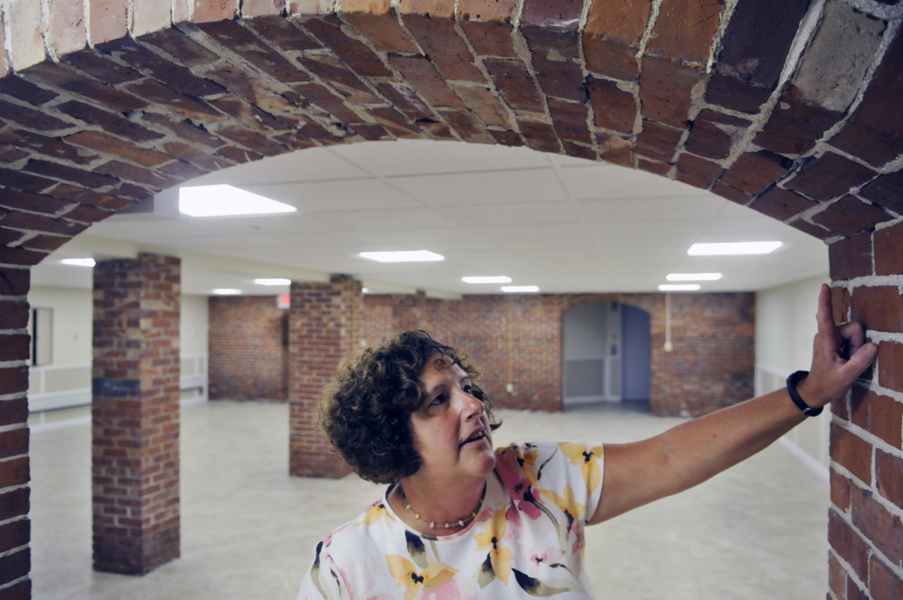 Gardiner Public Library Director Anne Davis inspects brick work Thursday in the recently renovated archivist room in the library’s basement. A consultant’s report recommended cutting the part-time archivist position and revising the formula for charging other member communities.