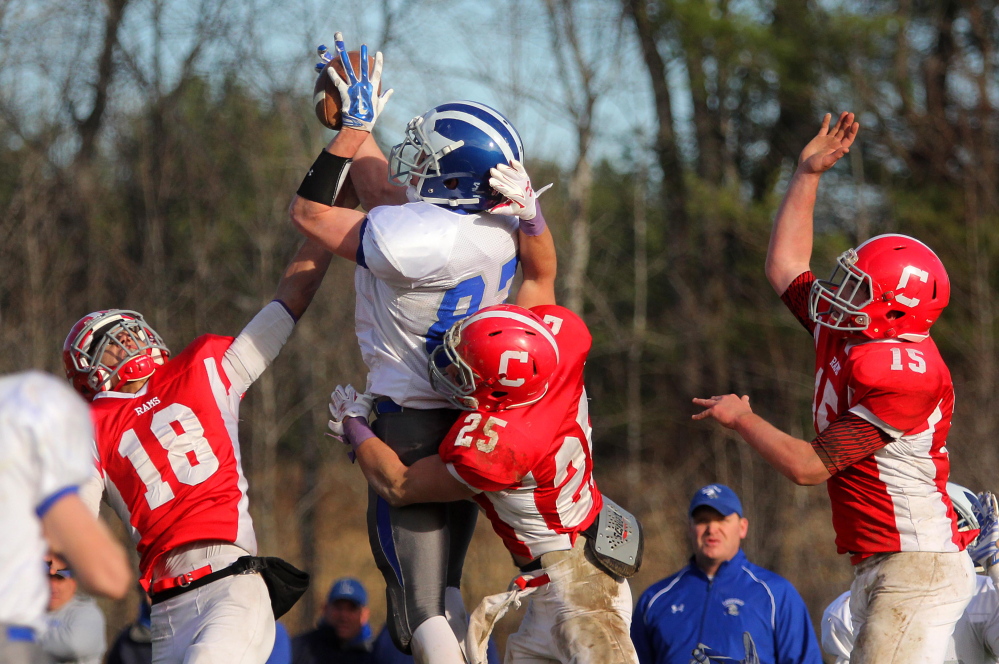 Photo by Jeff Pouland 
 BIG PLAY: Lawrence High School's Seth Powers makes a leaping catch for a touchdown over Cony defenders Anthony Brunelle (18), Tayler Carrier (25) and Mitchell Caron (15) with just 5.2 seconds left in the first half of a Pine Tree Conference Class B seminfinal game in Augusta last season. The Bulldogs rallied for a 28-27 victory.