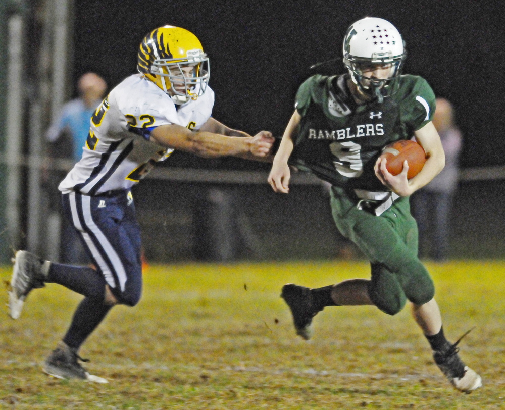 Staff file photo by Joe Phelan 
 Winthrop/Monmouth quarterback Matt Ingram scrambles to pick up some yards during a game against Boothbay last fall.