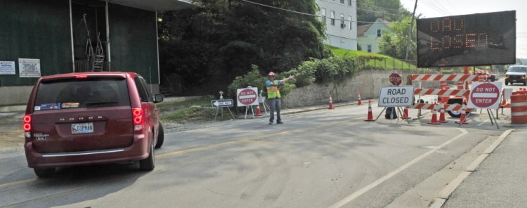 Flagger Raymond Braley points to a “road closed” sign Thursday as a driver why it’s necessary to turn around before a temporarily one-way section of Mount Vernon Avenue in Augusta.