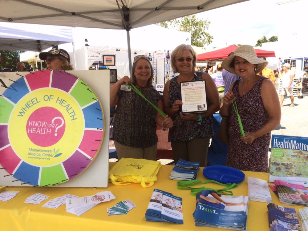 Dr. Lara Walsh, far left, of Winthrop Pediatrics, talks to festivalgoers Aug. 15 about the Wheel of Health while from left, Kathie Clark, Beth Corey-Smith, and Carol Cortes, all employees of Winthrop Family Medicine, show how to use exercise bands.