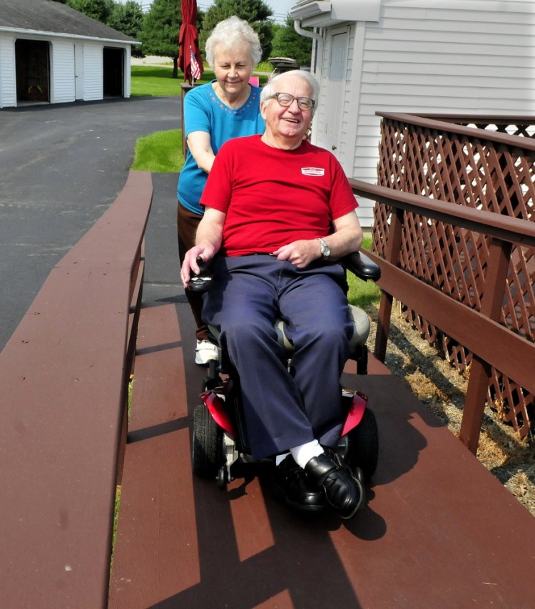 Larry Plourde makes his way up a wheelchair ramp as his wife, Noella, follows on Aug. 31 at their home in Winslow. Larry Plourde has cerebellar ataxia, which causes balance and mobility problems.