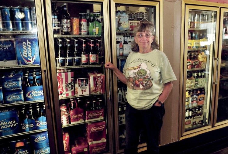 Patty Dowse, owner of the Cambridge General Store, stands beside the beer cooler Aug. 30 in Cambridge’s only store. The town’s ordinances allow beer to be sold all week, but wine and other alcoholic beverages, such as Twisted Tea, can be sold only on Sundays.