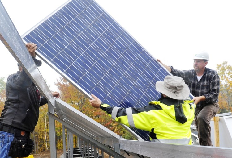 In this October 2014 file photo, workers install a solar electric panel in a ground-mounted solar array for Mt. Abram ski resort, similar to the ground-mounted solar array that is planned for a community solar farm in Wayne.