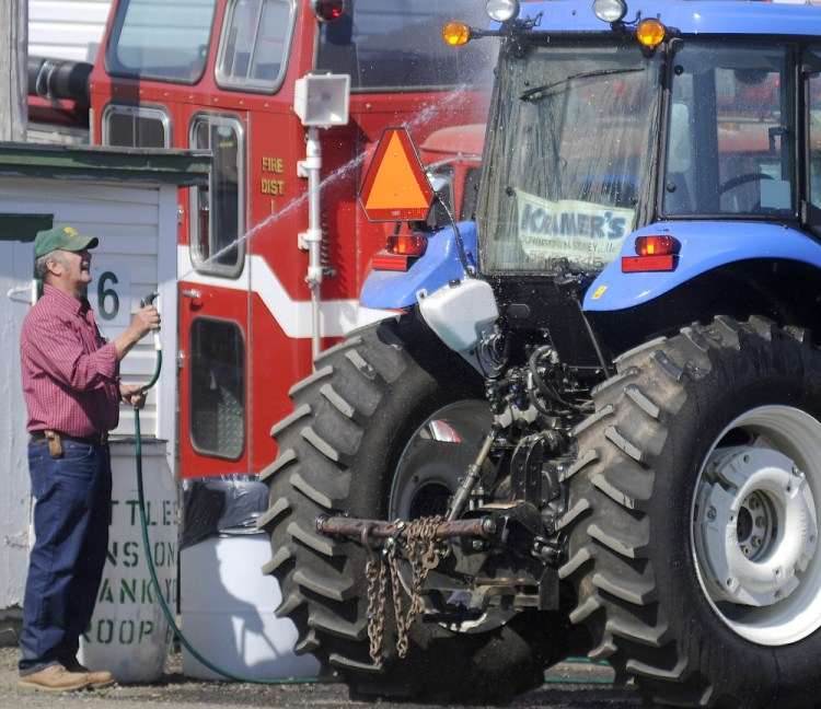 Greg Baker, of Pittston, washes a tractor Sunday at the Windsor Fair. Baker and his wife, Sue, work several hours during the week of the fair, supervising the pulling ring.