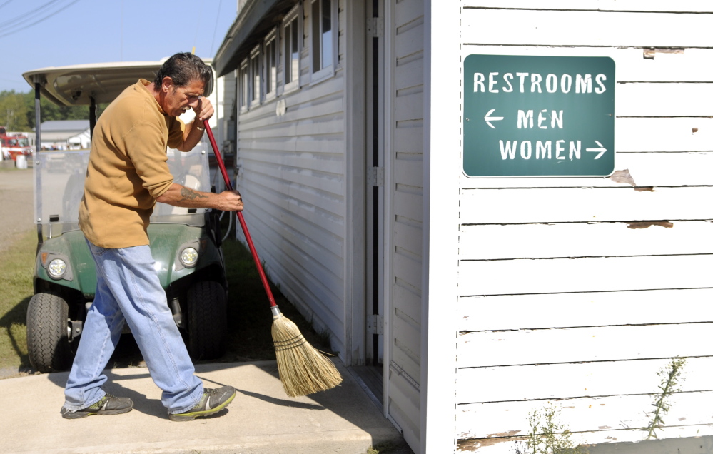 Edward Katz cleans a restroom Sunday at the Windsor Fair. Katz works several hours during the week of the fair, maintaining the facility for tips.