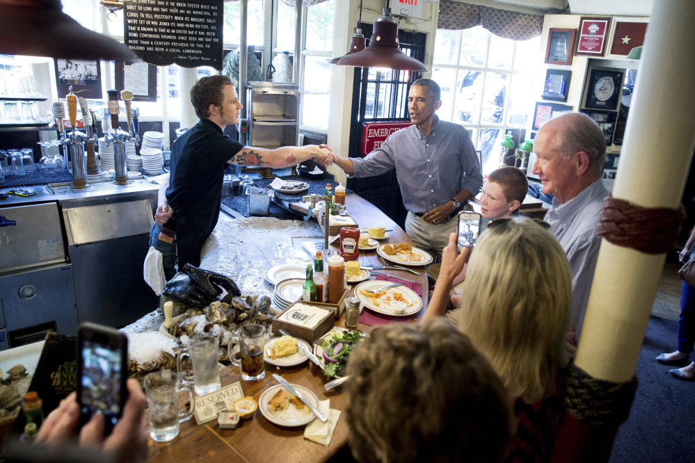 Greets people at Ye Olde Union Oyster House, Monday, Sept. 7, 2015, in Boson. Obama will sign an Executive Order requiring federal contractors to offer their employees up to seven days of paid sick leave per year. (AP Photo/Andrew Harnik)