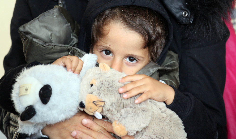 A migrant child holds cuddly toys at the Westbahnhof station in Vienna, Austria, Monday, Sept. 7.