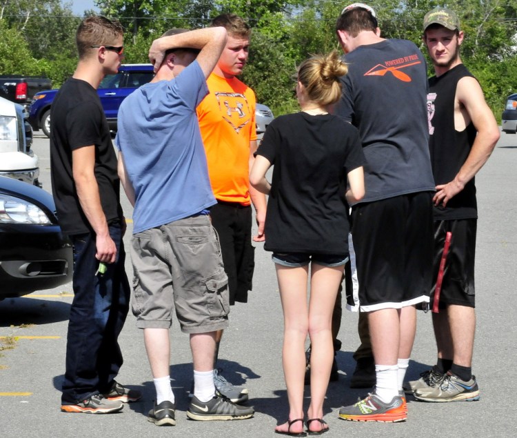 Friends, classmates and members of the Skowhegan Area High School football team gather on Monday outside the school after a memorial service for student Scott Brown, who died Sunday evening while swimming in Embden Pond in Embden.
