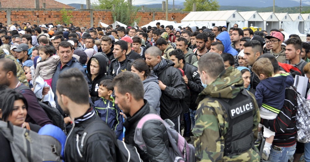 People gather as they prepare to leave a refugee camp in the southern Macedonian town of Gevgelija, Tuesday.