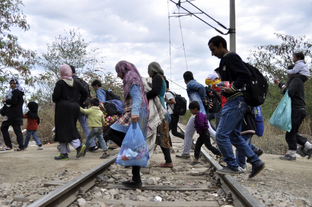 People pass railway tracks as they approach the southern Macedonian town of Gevgelija,Tuesday.
