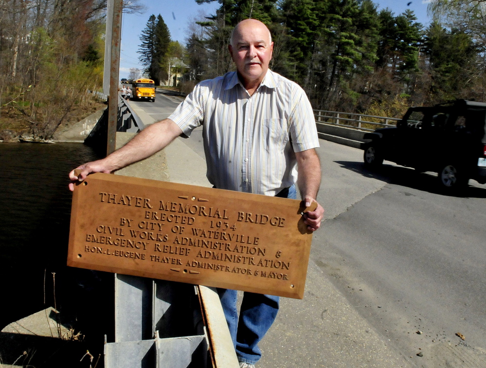 Waterville Public Works Director Mark Turner holds a bronze plaque in May at the Gilman Street bridge. The plaque was recently found and the bridge will be rededicated Thayer Memorial Bridge Saturday.