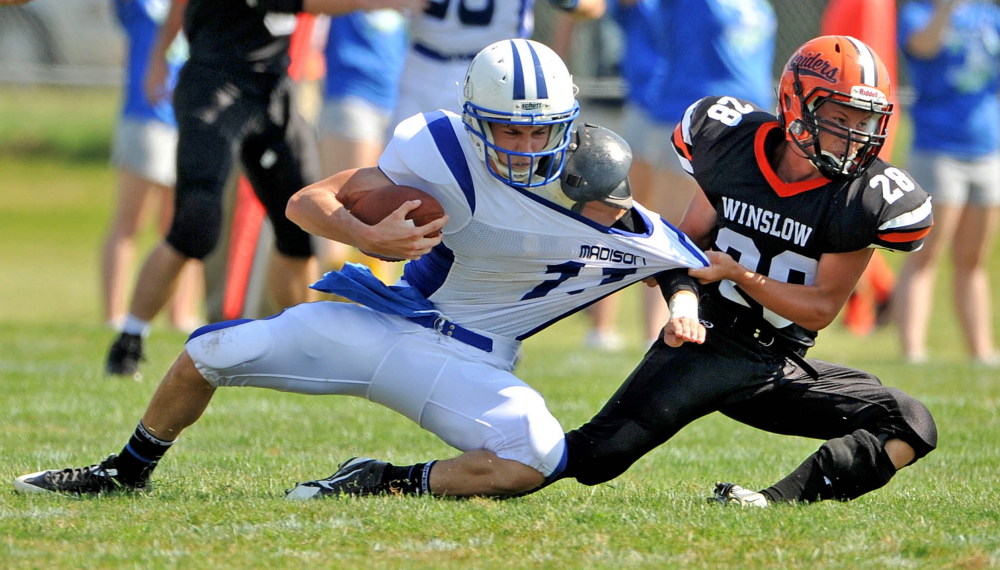 Staff Photo by Michael G. Seamans
Madison quarterback Chase Malloy tries to elude a Winslow’s Luke Frddette during a game last Sept. 6 in Winslow.