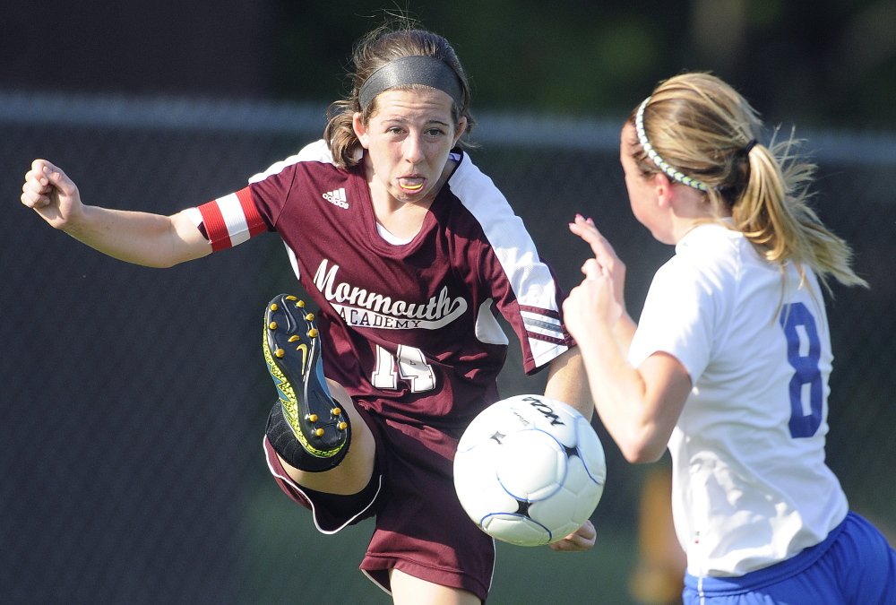 Staff photo by Andy Molloy 
 Monmouth Academy's Taylor Spadafora, left, kicks the ball away from Oak Hill's Rylea Mae Swan during a Mountain Valley Conference game Wednesday afternoon.
