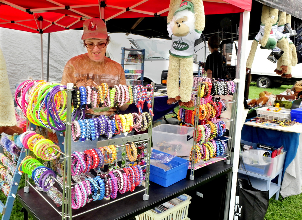Melody Braley sets out crafts and other novelties for sale at the Clinton Lions Club fair on opening day Thursday.