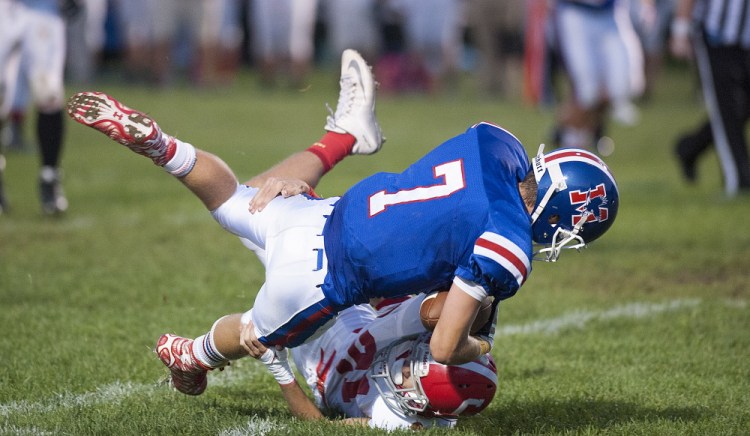 Photo by Kevin Bennett 
 Cony's Lucas Tyler brings wraps up Messalonskee's Cody Dexter during the first quarter of a game Friday night in Oakland.