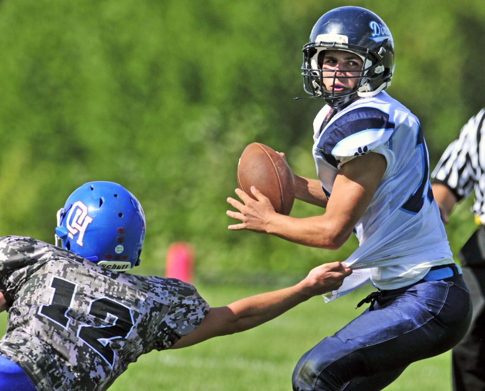 Oak Hill defensive end Matthew Strout, left, grabs the shirt but can’t hang on to Dirigo quarterback Riley Robinson during third quarter Saturday in Wales.