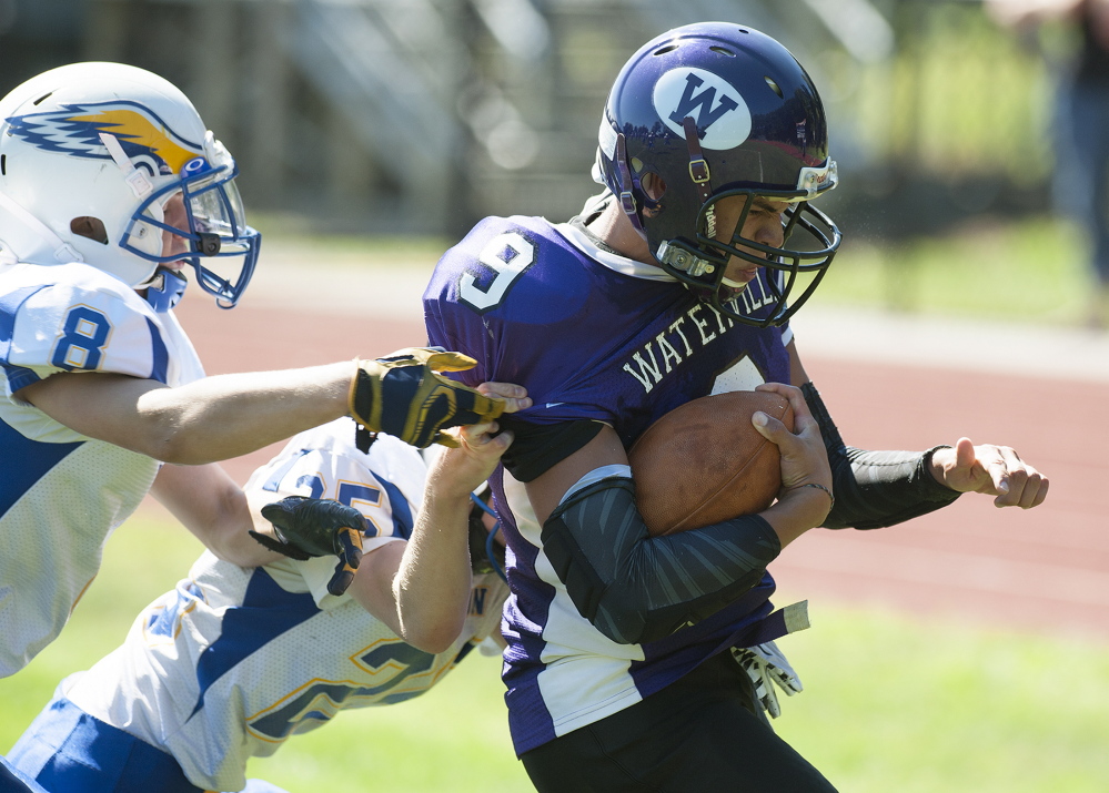 Kevin Bennett photo 
 Waterville's Demetrius Ramirez manages to score a touchdown despite the pressure from Hermon defenders Tyler Carmichael, left, and Jacob Baily during the first quarter Saturday afternoon.