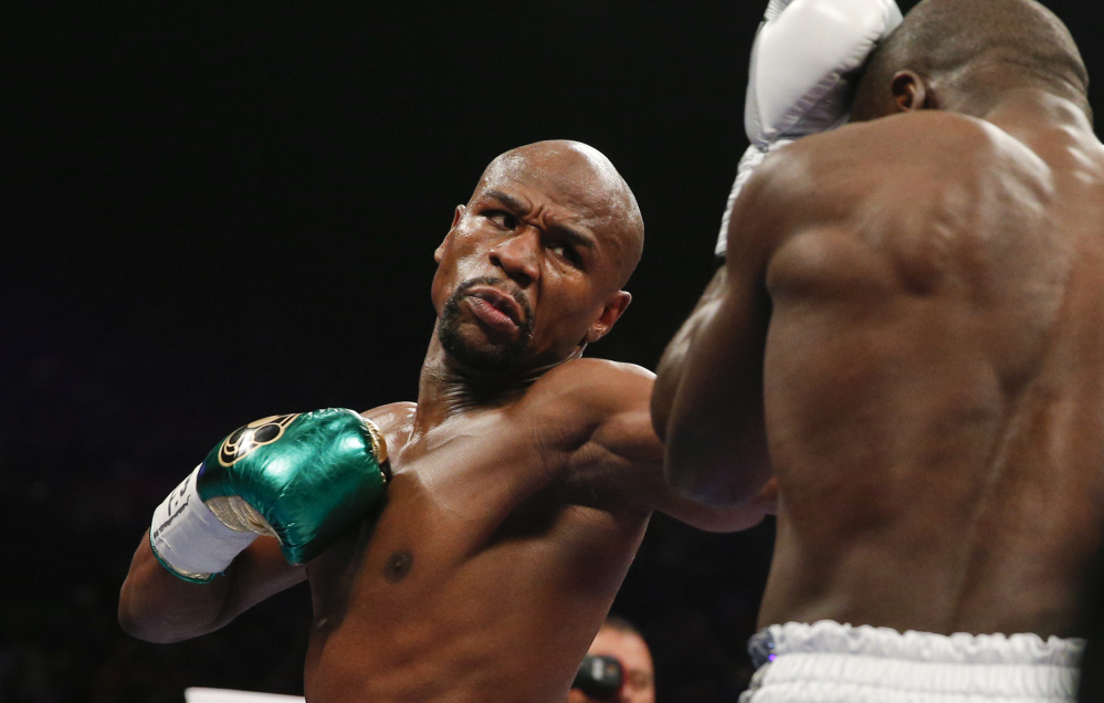 Floyd Mayweather Jr. hits Andre Berto during their welterweight title boxing bout Saturday in Las Vegas.