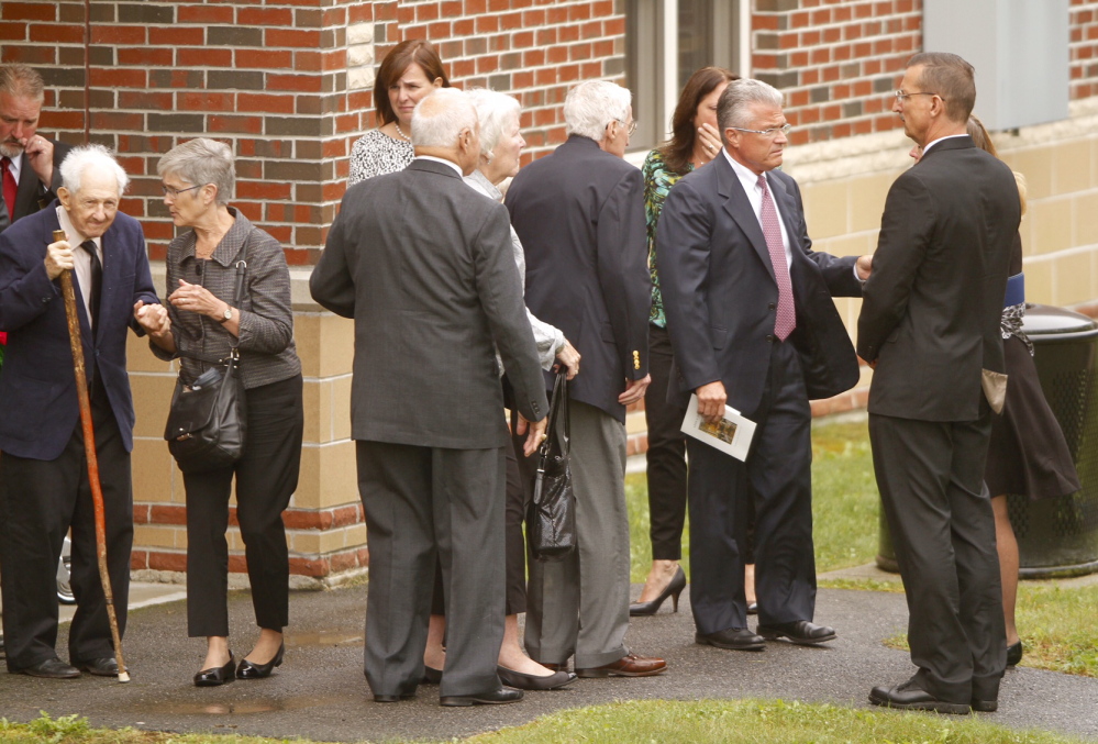 Members of former L.L. Bean leader Leon Gorman’s funeral, including current CEO Christopher McCormick, second from right, gather after Gorman’s memorial service at the Westbrook Performing Arts Center on Sunday.