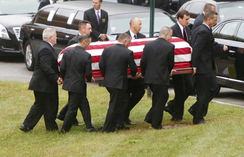 Pallbearers carry the flag-draped casket of former LL Bean leader Leon Gorman from his memorial service at the Westbrook Performing Arts Center on Sunday.